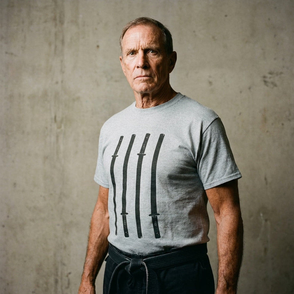 Man wearing a gray t-shirt with black designs against a textured wall